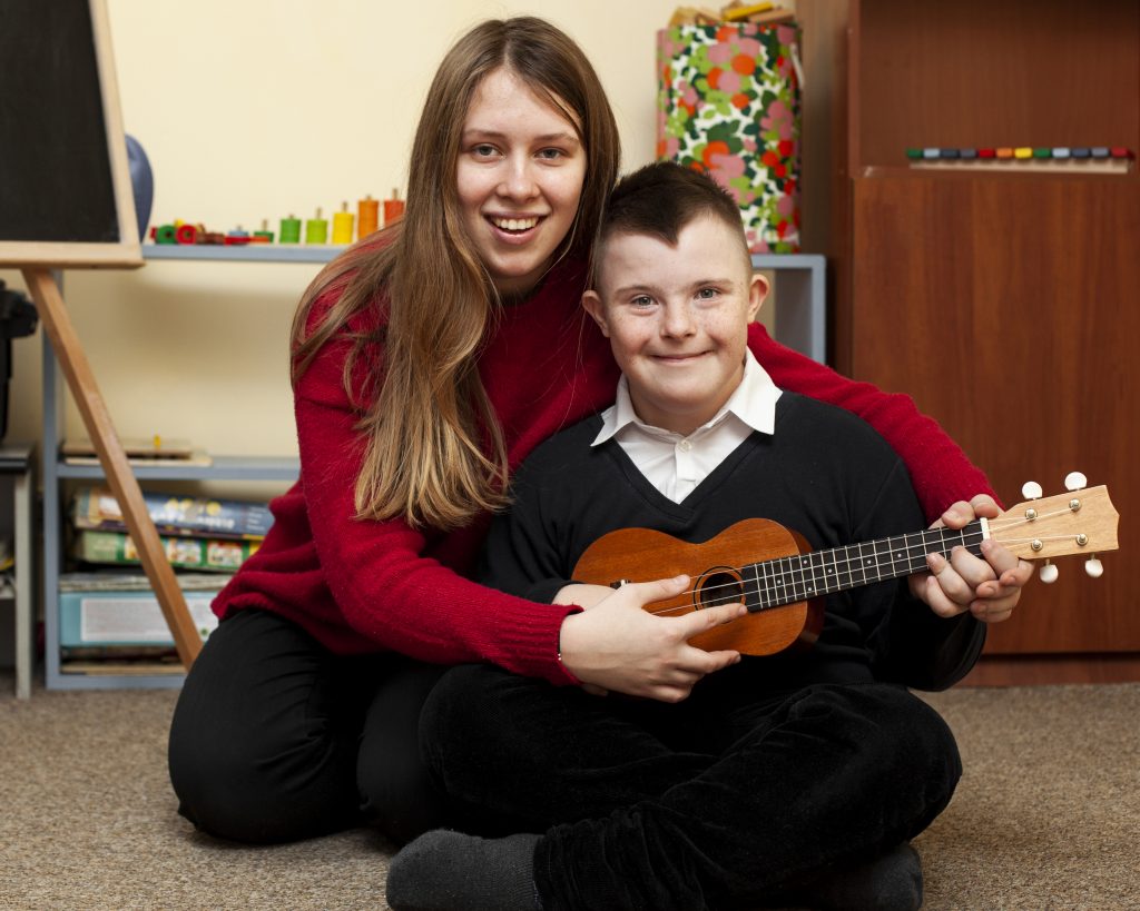 SEN teaching assistant helping child with music